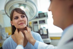 Doctor examining a female patients neck