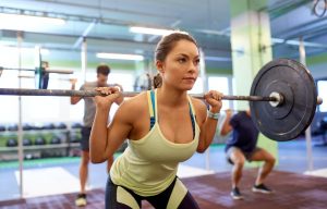 group of people training with barbells in gym