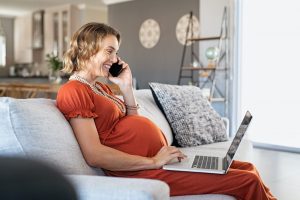 Pregnant woman working at home with laptop