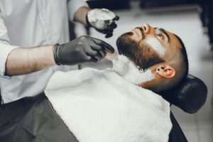 The man cuts his beard in the barbershop