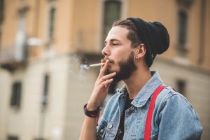 young handsome bearded hipster man smoking cigarette