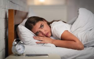Young Woman Suffering From Insomnia Lying In Bed At Home