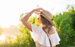 Woman in big straw hat enjoyed with summer sun