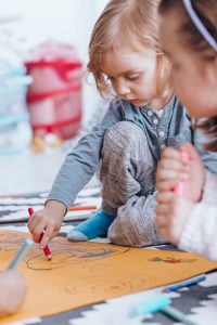 Young boy drawing with classmate